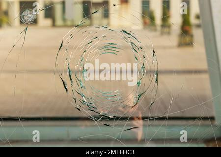 Broken glass with a hole and cracks on the street Stock Photo