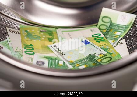 European one hundred euro banknotes in washing machine. Money laundering financial concept Stock Photo