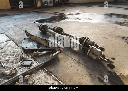 Close shot of car drive shafts lying on the floor. Repair shop concept. High quality photo Stock Photo