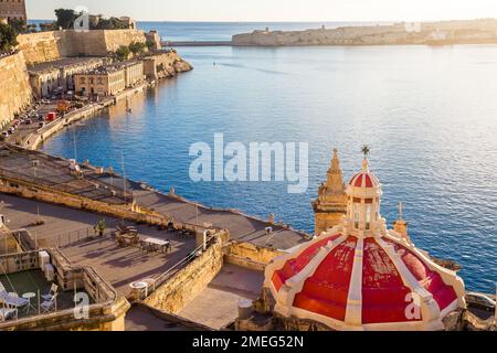 Valletta, Malta - The old harbor of Valletta with red painted church roof on a sunny summer sunrise Stock Photo