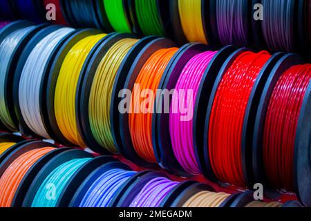 Many multi-colored spools of thread of filament for printing 3d printer. Material coils for printing 3D printer. Spools of 3D printing motley different colors filament. ABS wire plastic for 3d printer Stock Photo
