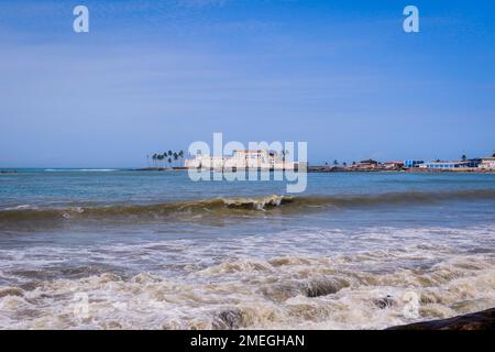 Far View to the Cape Coast Slave Castle from the  Atlantic Ocean Coastline in Ghana, West Africa Stock Photo