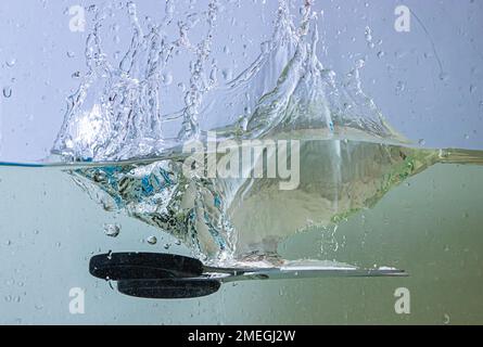 scissors fall into the water. sprays, drops and bubbles Stock Photo