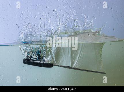 scissors fall into the water. sprays, drops and bubbles Stock Photo