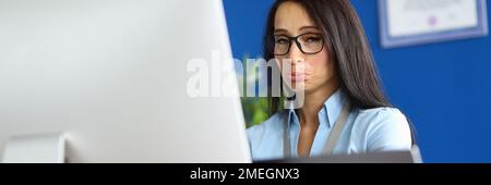 Offended woman works on computer in office Stock Photo