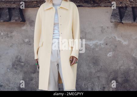Milan, Italy - February 25, 2022: Crop anonymous female in white coat and stylish trousers. Stock Photo