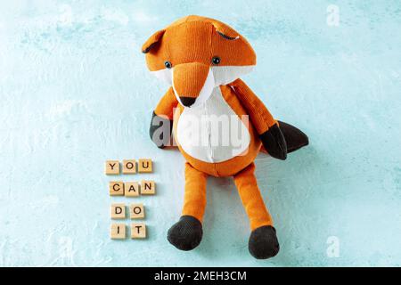 You can do it, motivational banner with letters and a toy fox on a blue background Stock Photo