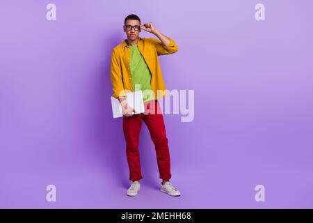 Full size photo of serious concentrated person hand touch eyeglasses hold netbook empty space isolated on violet color background Stock Photo