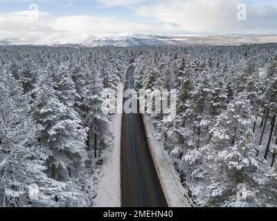 Aerial view of road in snow Rothiemurchus forest  in Cairngorms national Park, Scottish Highlands, Scotland, UK Stock Photo