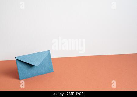 Navy color envelope on red table. white wall background. minimalism, copy space Stock Photo