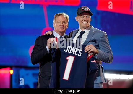 Alabama quarterback Mac Jones, right, holds a team jersey with NFL  Commissioner Roger Goodell a …