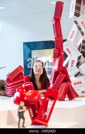 London, UK.  24 January 2023. A staff member poses with works from the 'Telephone Box Maquette', 2019, series at a preview of ‘Heavy Metal’, a new exhibition by David Mach RA at Pangolin London gallery in King’s Cross. The show runs to 25 March. Credit: Stephen Chung / Alamy Live News Stock Photo