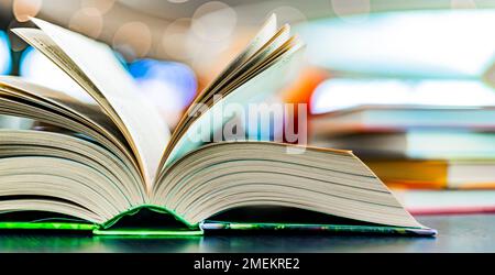 An open hardcover book on a table in a public library Stock Photo