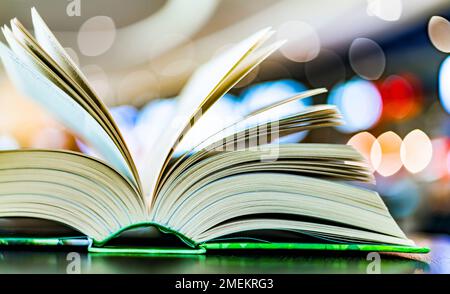 An open hardcover book on a table in a public library Stock Photo