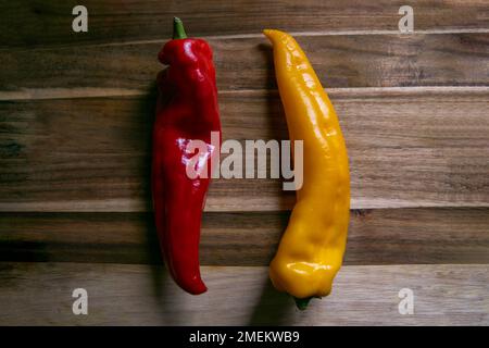 Two isolated paprica paprika poivron peppers, yellow and red, long. Raw, vegan, vegetarian. Delicious food blogger photo, colorful, dark. Stock Photo