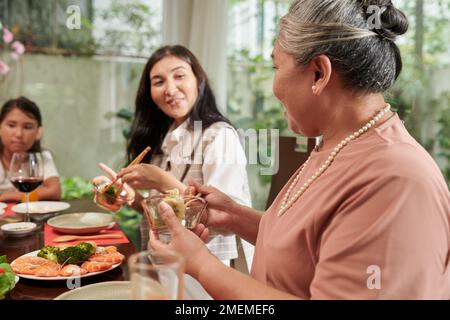 Happy family eating traditional dishes at Tet celebration at home Stock Photo
