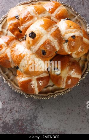 Homemade Hot Cross Buns Ready for Easter closeup on the plate on the table. Vertical top view from above Stock Photo