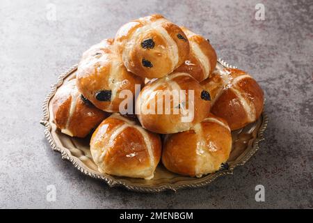 Hot Cross Buns are a traditional English Easter pastry close-up in a plate on the table. Horizontal Stock Photo