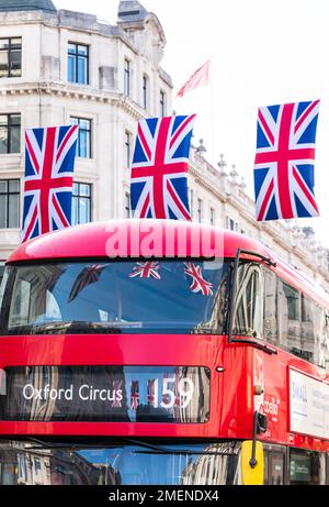 Union Jack flags reflected in the red London bus on Regent Street, London, England Stock Photo