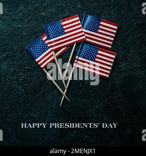 text presidents day and a flag of the united states of america lying on a rustic table, against a black background Stock Photo