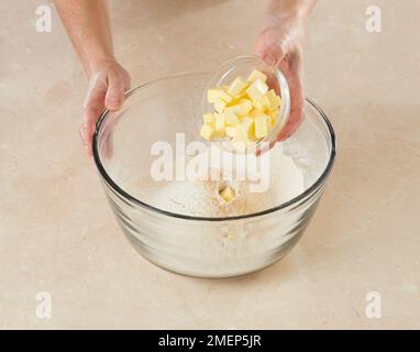 Making Gingerbread Men, adding butter to flour, bicarbonate of soda, and spices Stock Photo