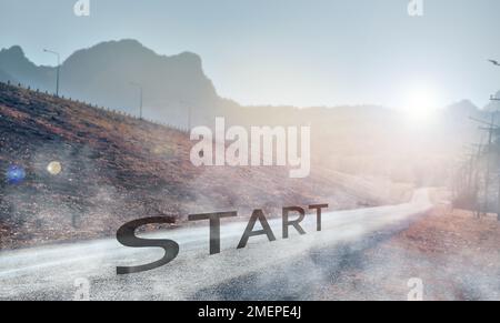 Starting point and journey on a paved road with sunrise in the valley, concept of beginning to success, selective focus Stock Photo