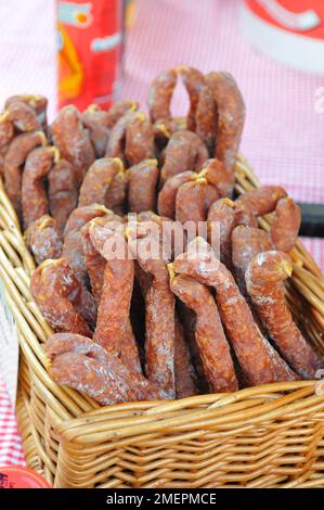 Wicker basket full of Pfefferwurst, small German Rohwurst sausages Stock Photo