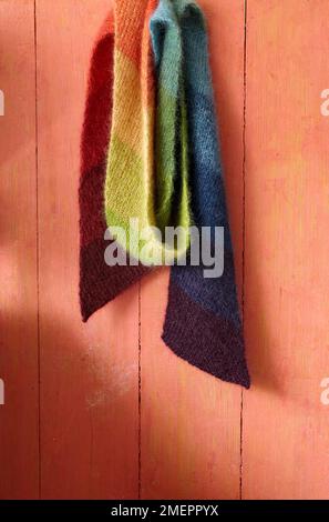 Mohair rainbow scarf hanging on wall Stock Photo