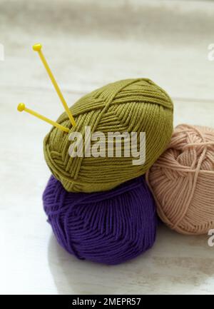Three balls of wool with knitting needles stuck in one Stock Photo