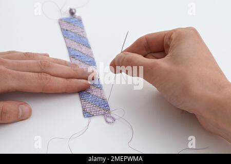 Making a loom-woven bead cuff, sewing loop, close-up Stock Photo