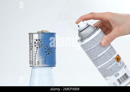 Spraying tin can lantern with blue paint, close-up Stock Photo
