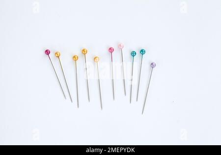 Row of sewing pins with coloured plastic heads, overhead view Stock Photo