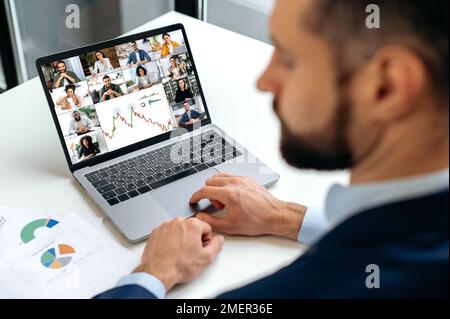 Online video conference. Caucasian successful business man, financial director, talking on video link with his colleagues, discussing financial strategy, analyzing charts, planning development Stock Photo