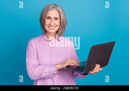 Photo of positive satisfied business woman entrepreneur working remote hold netbook online freelance website isolated on blue color background Stock Photo