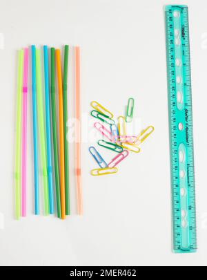 Colourful drinking straws, paper clips, and a ruler Stock Photo