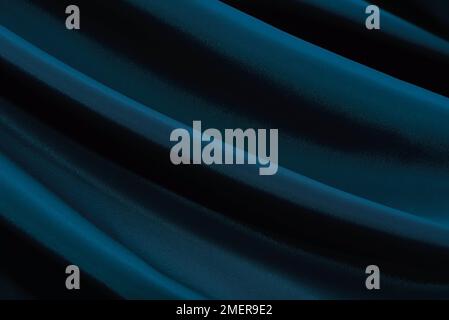 Abstract background of dark blue satin or silk fabric with waves. View from above. texture blue. Valentine, Christmas Stock Photo
