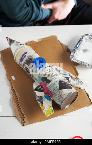 Making rocket pen pot, covering tube with papier-mache Stock Photo