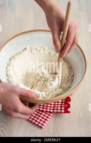 Mixing flour, bicarbonate of soda and ginger, making gingerbread biscuits Stock Photo