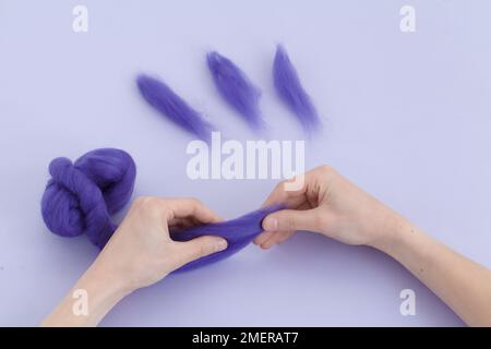 Making felt balls (felting), separating tufts of wool Stock Photo