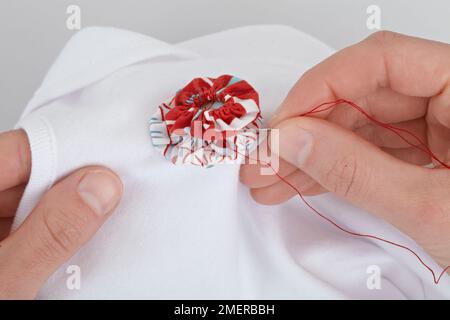 Stitching a rosette on onesie Stock Photo