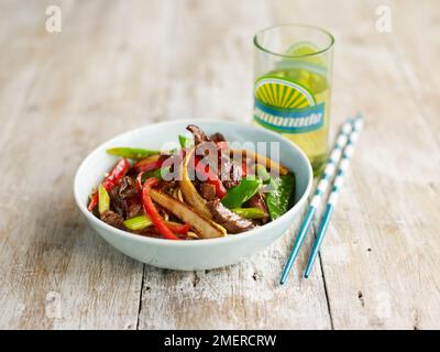 Beef and vegetable stir-fry containing sweetcorn, peppers, and mangetouts Stock Photo