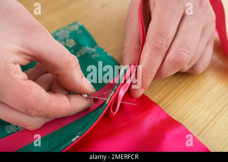 Thai silk manicure roll, fold ribbon and pin the end into the top left corner of the pocket Stock Photo
