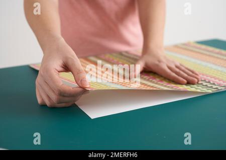 Glue decorative paper on to card Stock Photo