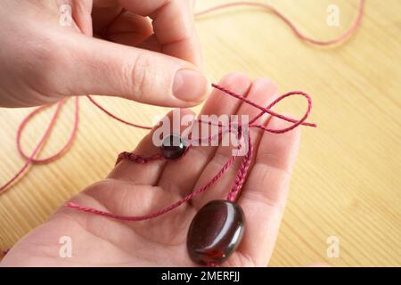 Making crochet necklace, Using a slip stitch to join necklace ends Stock Photo