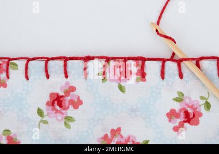 Blanket stitch the edge of fabric Stock Photo