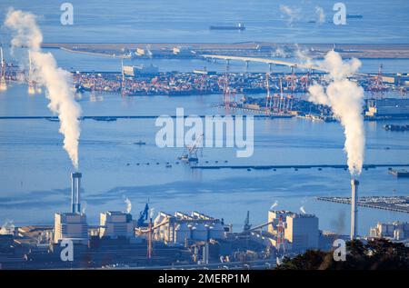 Smokestack emissions over loading zone at industrial port Stock Photo