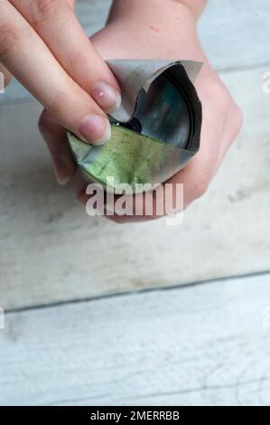 Making a seed pot made of newspaper Stock Photo