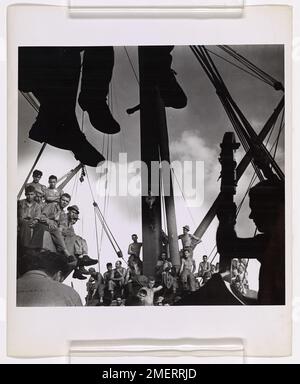 Coast Guardsmen Entertain Invasion Bound Troops. U.S. Coast Guardsmen gave countless 'jam' sessions for soldiers aboard a Coast Guard manned combat transport bound for the invasion of Makin. The musicians, one of whom is silhouetted at the right, were crew members. The Coast Guard transport was a member of the Navy task force participating in the invasion. Stock Photo