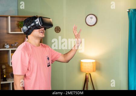 young man waving hand by wearing virtual reality or vr headset during online meet at metaverse or virutal world - concept of futuristic, technology Stock Photo