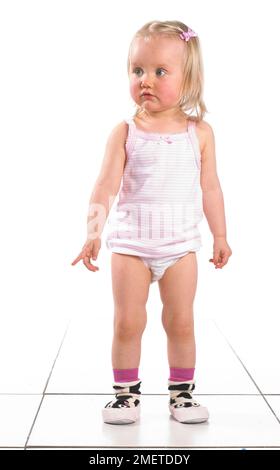 Girl wearing vest, pants and slippers, 20 months Stock Photo